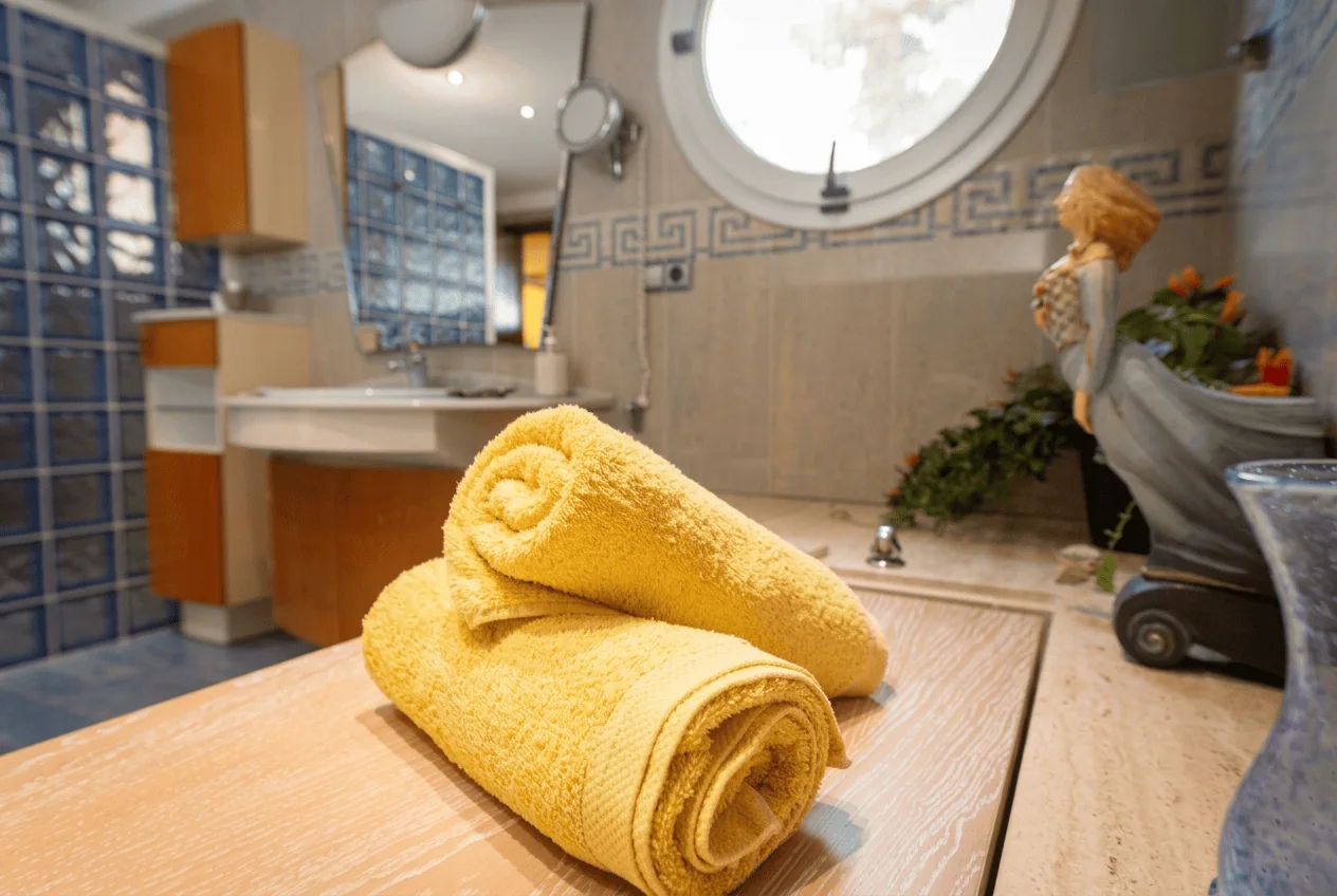Baño con luz natural y toallas recién dobladas