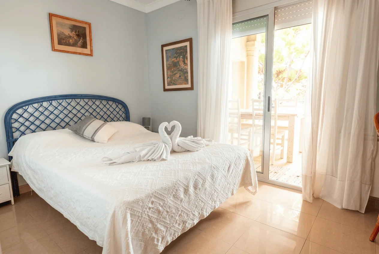 Habitación luminosa con cabecero azul y salida a la terraza